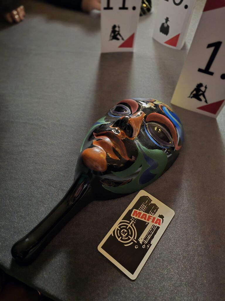 Mafia mask and playing card on the table, theme 