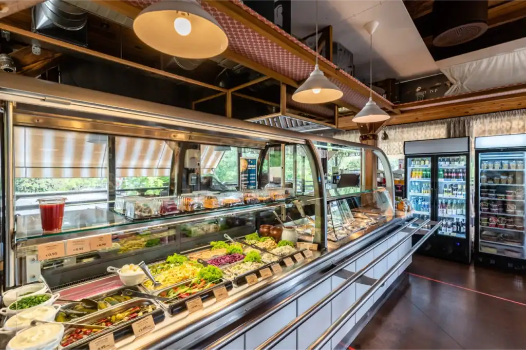 Ramkalni shop fridge with a variety of fresh produce and salads.