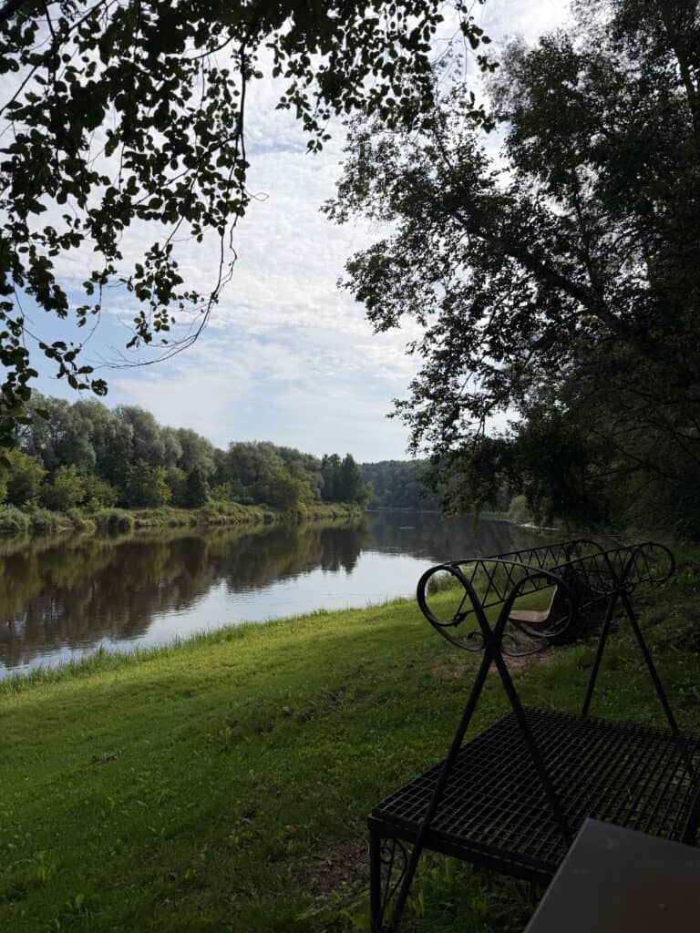 A picnic spot with benches and a view of the river, set against a natural landscape.