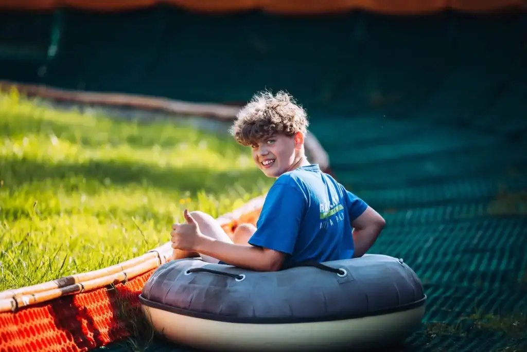 A child with a boat in the garden, happy and joyful, summer holidays.