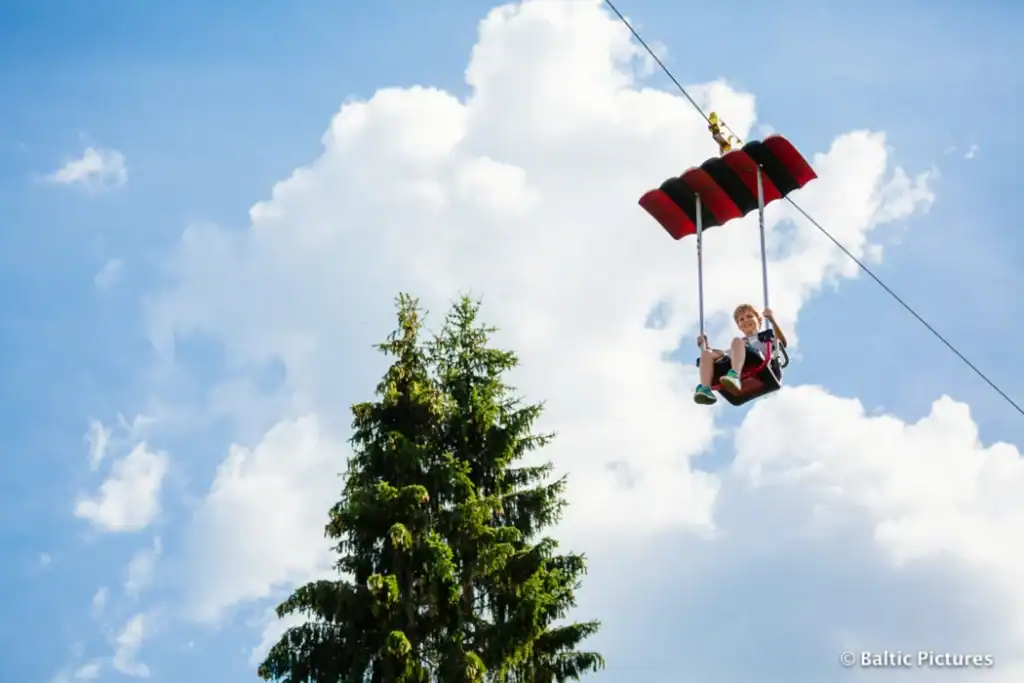 Flying chair with a child flying over the forest and sky.