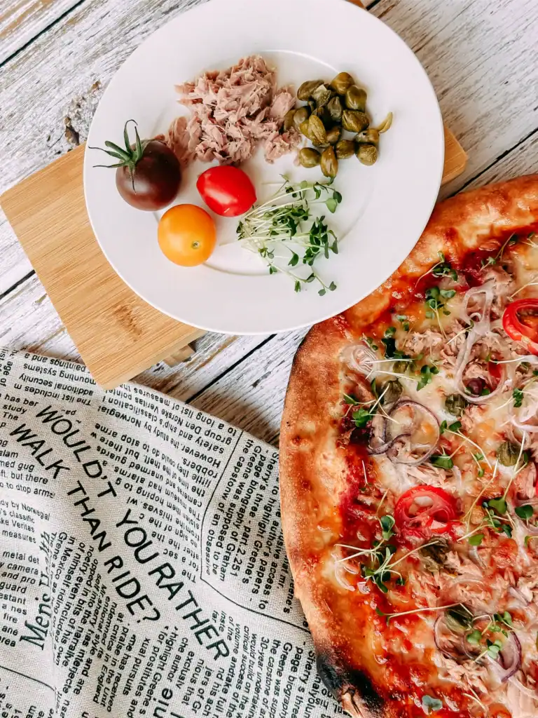A picture of a healthy pizza and its ingredients; a presentation of healthy food.