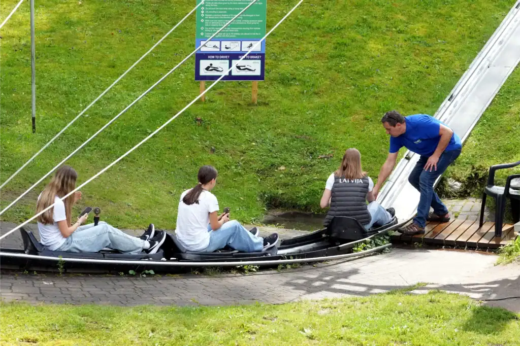 Children and adults are playing on the playground hill; active outdoor fun.