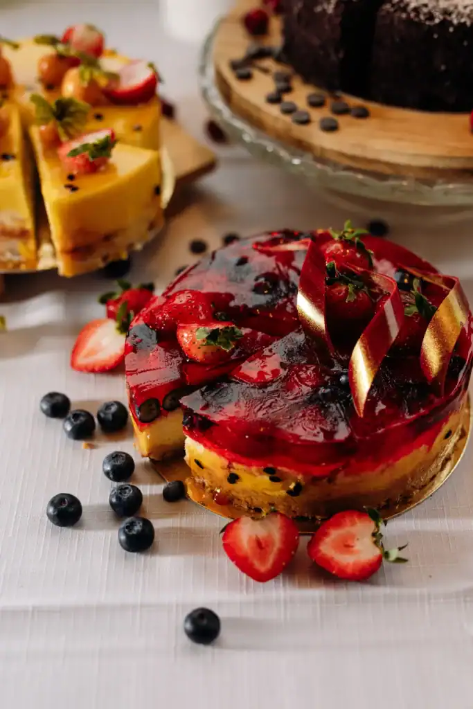 Cakes with strawberry and chocolate icing, decorated with berries and chocolate shavings.