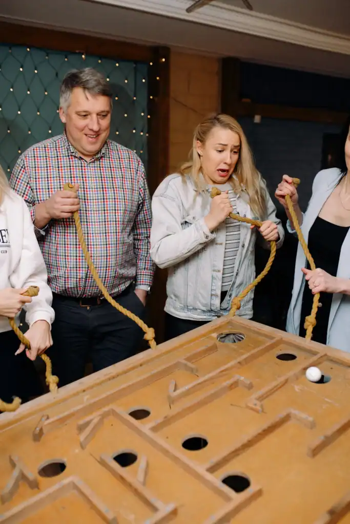 A group of people play indoor games with a rope, having fun and socialising.