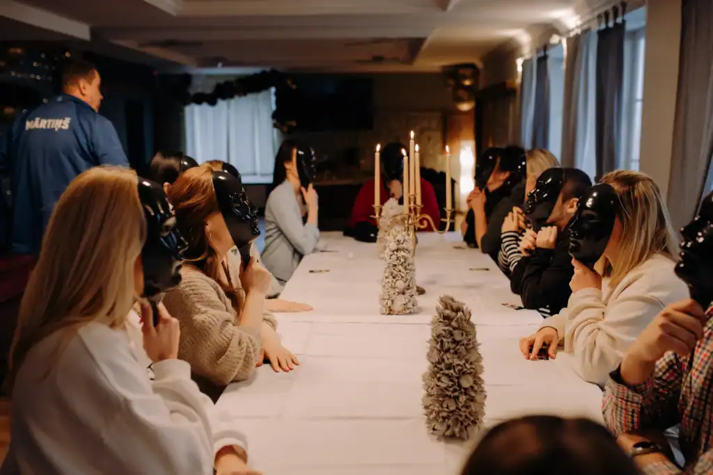Groups of people play indoors with masks and board games, in a fun atmosphere.